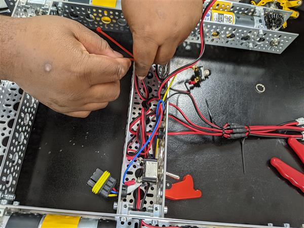 Student is cleaning up loose wires with zip ties