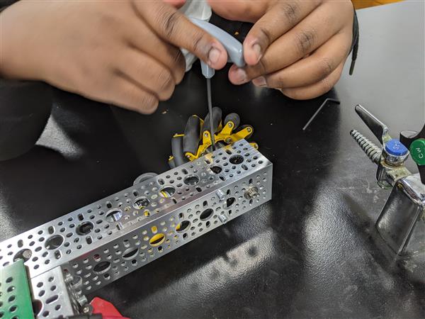 Student attaches wheels to the robot