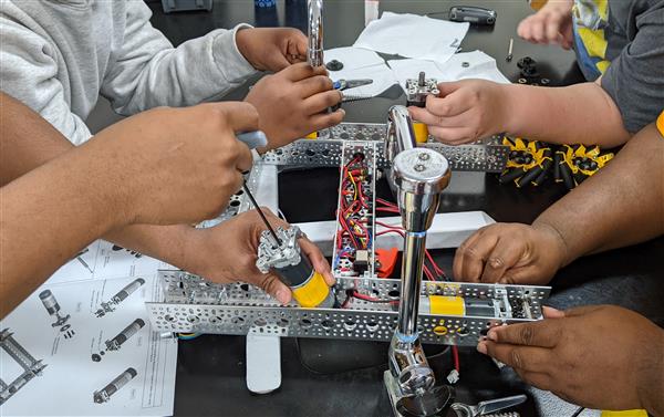 Four students work on robot simultaneously